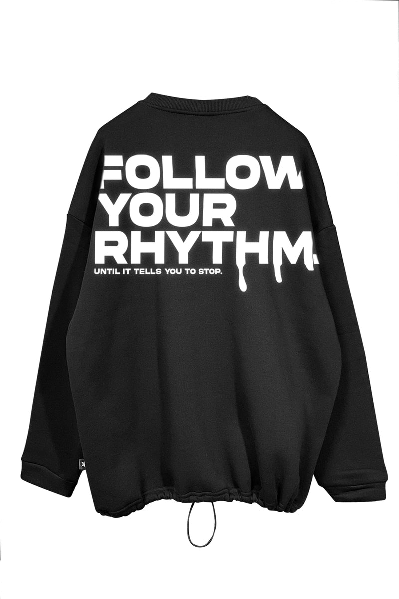 Unisex black oversize sweatshirt with 'Follow Your Rhythm' text, perfect for music and rave culture fans.